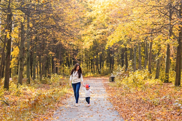 Madre con su bebé. Mamá e hija en un parque de otoño.