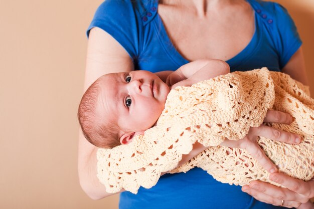 Madre con su bebé recién nacido, de pie junto a la pared