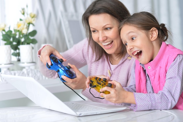 Madre con su hija disfrutando de una laptop