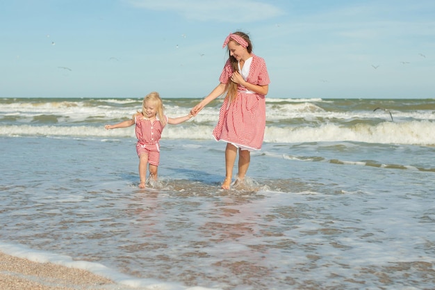 Madre y su hija divirtiéndose en la playa