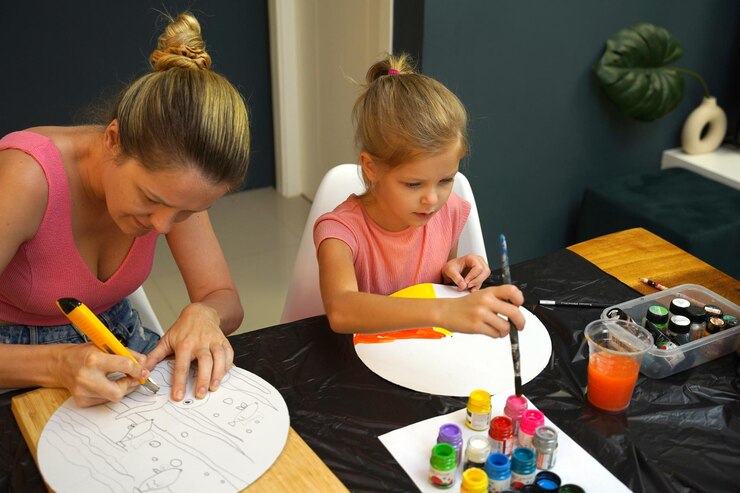 Foto una madre y su hija pequeña participan en una actividad de pintura colorida
