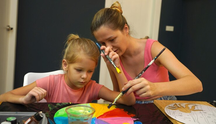 Foto una madre y su hija pequeña participan en una actividad de pintura colorida