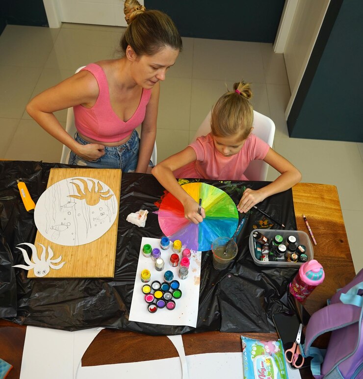 Foto una madre y su hija pequeña participan en una actividad de pintura colorida