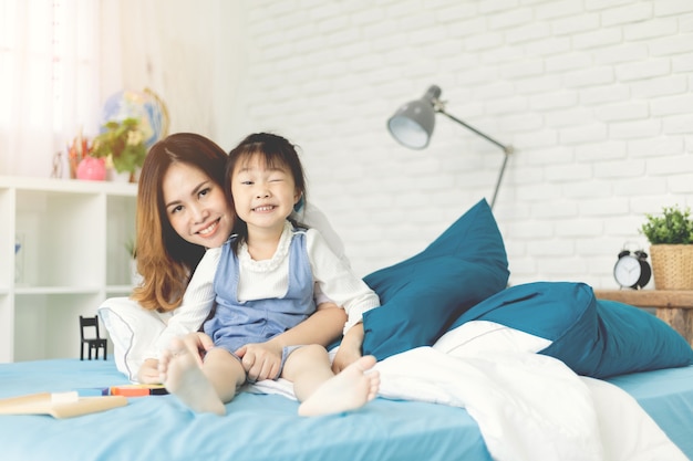 Madre y su hija relexionando en la cama en casa.