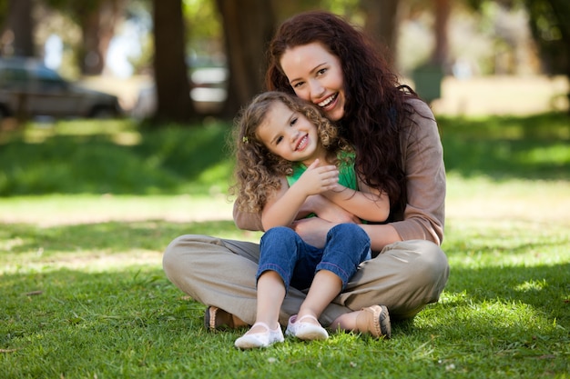 Madre con su hija sentada en el jardín