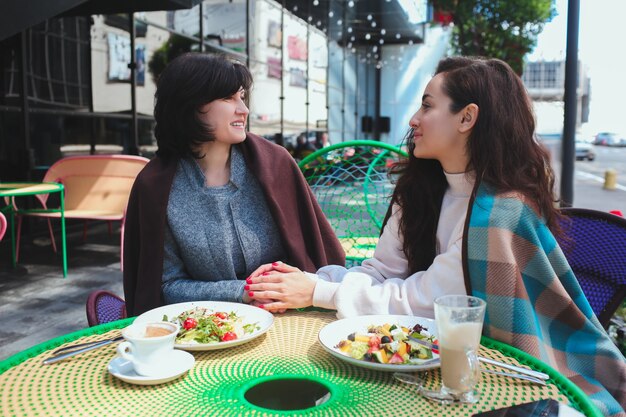 Madre y su hija se sientan juntas en el café