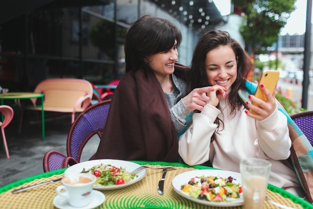 Madre y su hija se sientan juntas en el café