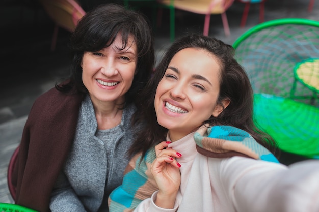 Madre y su hija se sientan juntas en el café