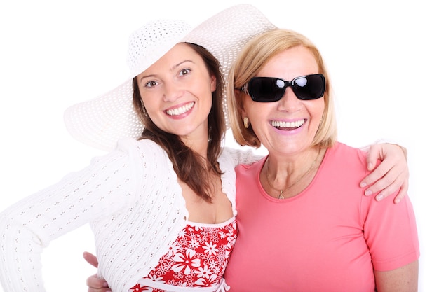 Una madre y su hija sonriendo sobre fondo blanco.