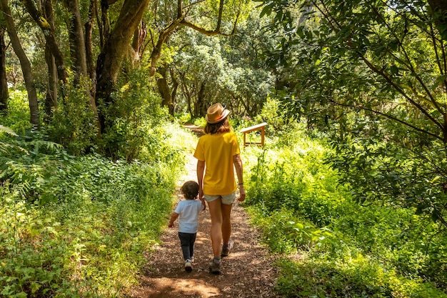 Una madre con su hijo caminando por el sendero de La Llania en El Hierro Islas Canarias exuberante paisaje verde