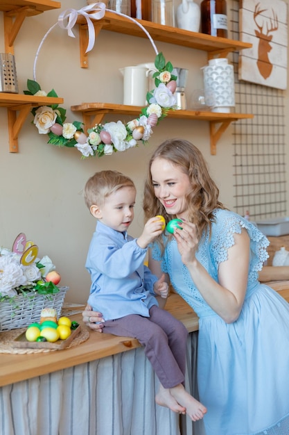 Una madre y su hijo en una casa decorada en primavera celebran la tradicional fiesta de Pascua