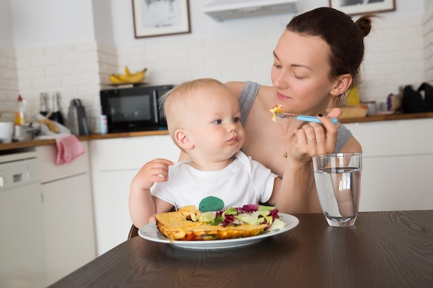 Madre con su hijo comiendo juntos y divirtiéndose