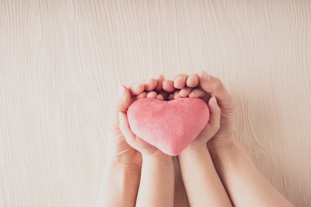 Madre y su hijo con corazón rosa con ambas manos