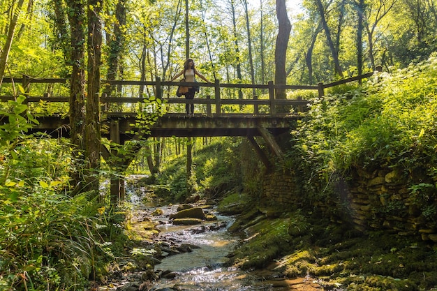 Una madre con su hijo cruzando un puente de madera en el parque de Pagoeta en Aia Guipuzcoa País Vasco