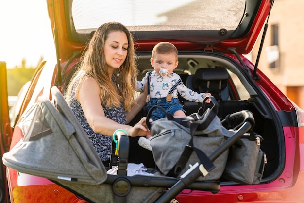 Madre con su hijo detrás del auto preparando el viaje