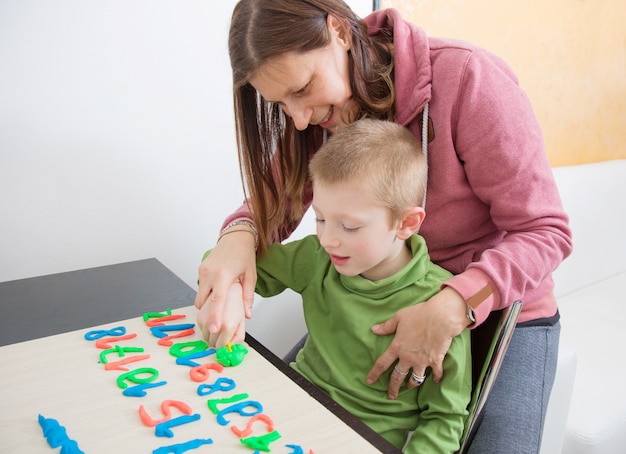 Foto una madre y su hijo juegan con plastilina de colores