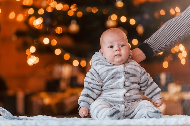 Madre con su hijo juntos en la habitación decorada de Navidad.