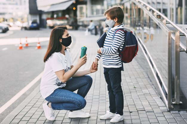 Madre y su hijo con máscaras protectoras al aire libre