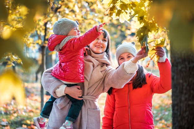 Madre y su hijo niña jugando juntos en otoño a pie