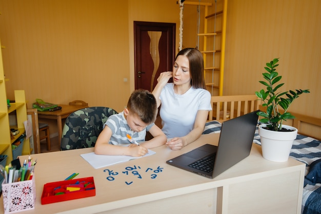 Foto una madre y su hijo participan en el aprendizaje a distancia en casa frente a la computadora. quédate en casa, entrenando.