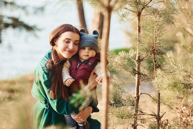 Madre con su hijo pequeño da un paseo por el bosque de primavera durante el día