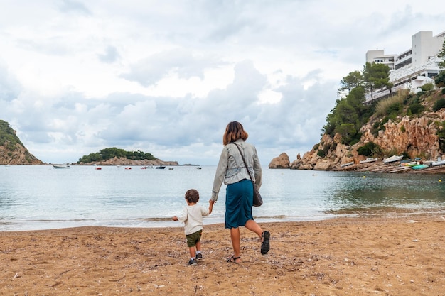 Una madre con su hijo en la playa del puerto de San Miquel en la isla de Ibiza Islas Baleares