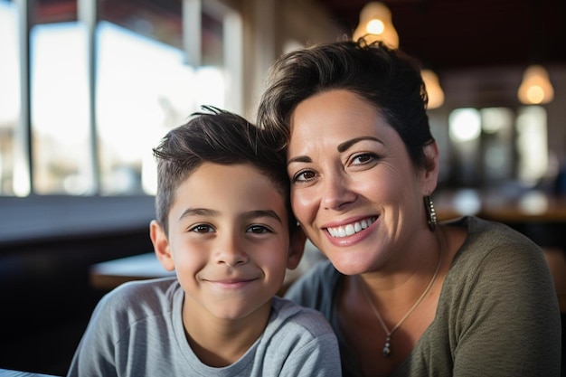 Una madre y su hijo posan para una fotografía en un restaurante.