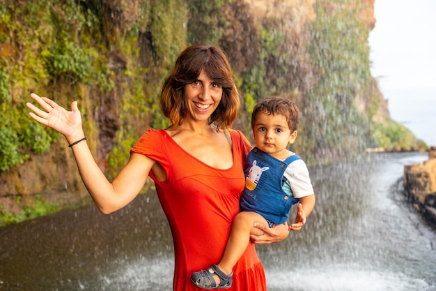 Una madre con su hijo de vacaciones en Anjos Waterfall Madeira divirtiéndose