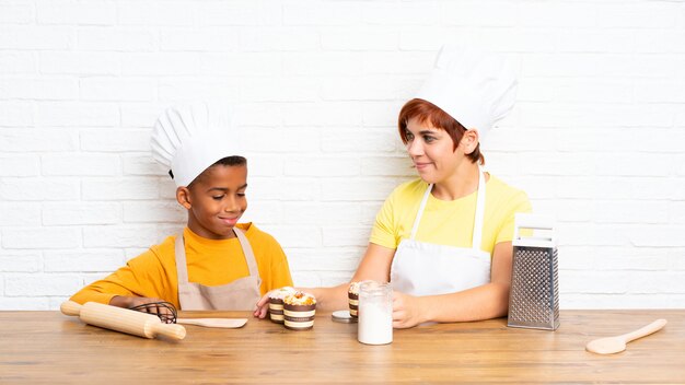 Madre y su hijo vestidos como chef en una cocina