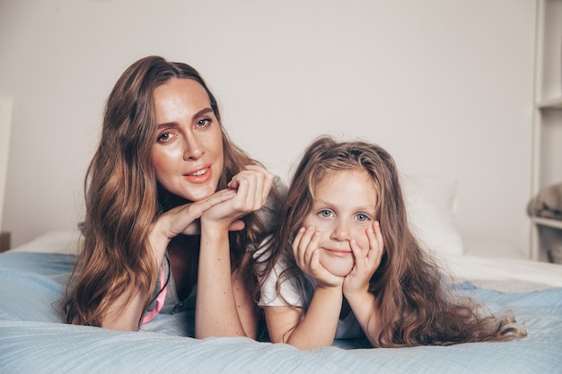 Madre y su linda hija preescolar en pijama