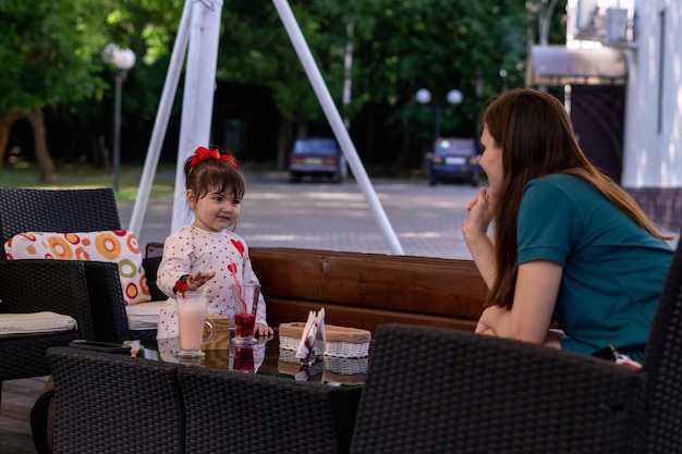madre con su pequeña hija disfrutando en un café al aire libre
