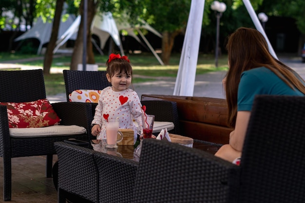 madre con su pequeña hija disfrutando en un café al aire libre