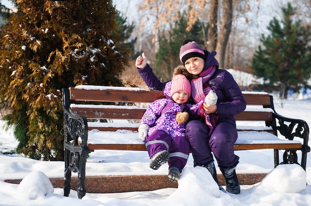 Madre y su pequeña hija disfrutando día de invierno.