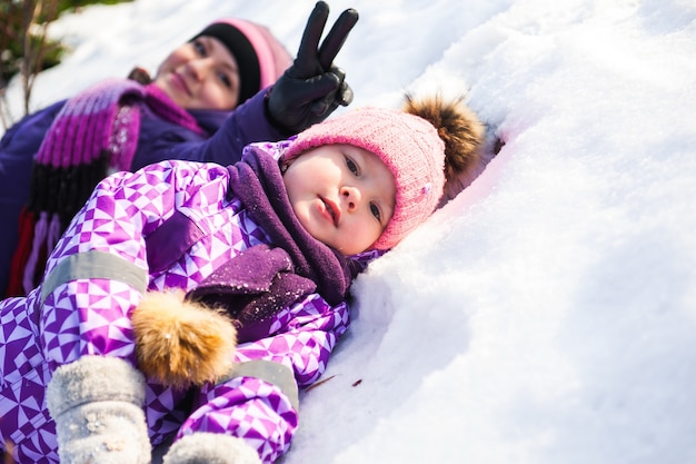 Madre y su pequeña hija disfrutando hermoso día de invierno