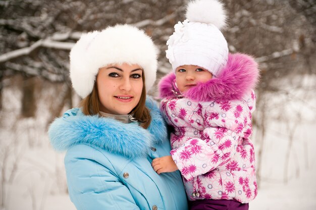 Madre y su pequeña hija disfrutando hermoso día de invierno