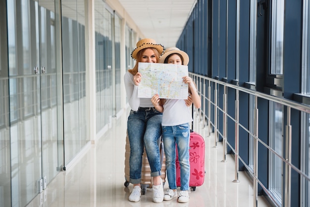 Madre y su pequeña hija con equipaje en el aeropuerto.