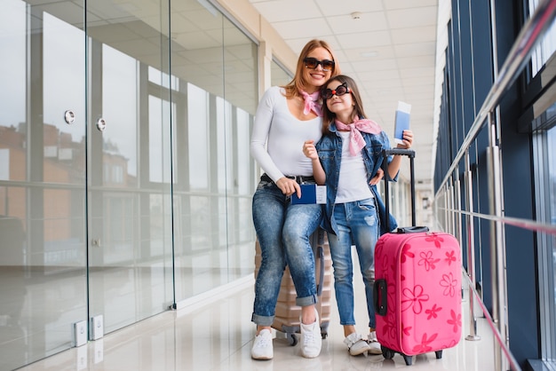 Madre y su pequeña hija con equipaje en el aeropuerto.
