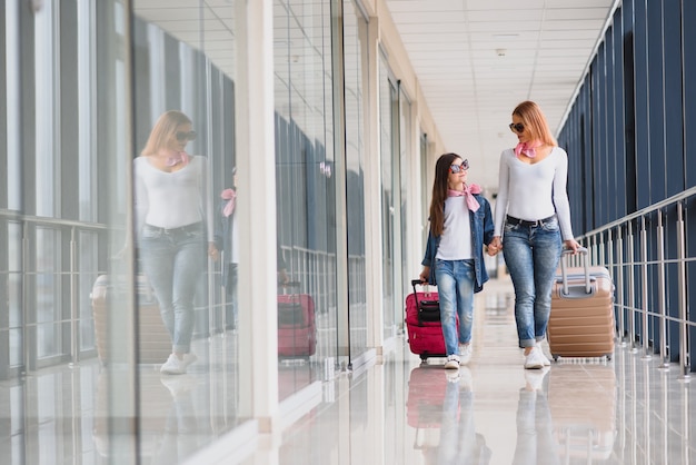 Madre y su pequeña hija con equipaje en el aeropuerto.