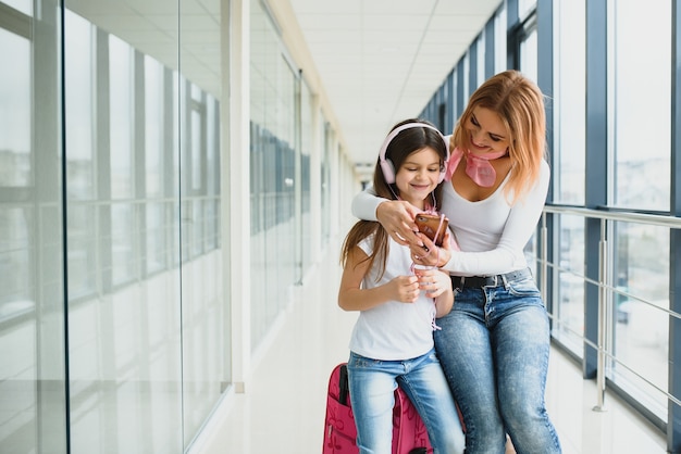 Madre y su pequeña hija con equipaje en el aeropuerto.