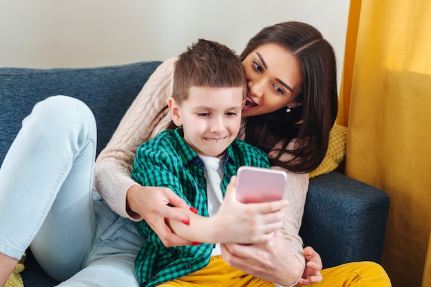 Madre y su pequeño hijo haciendo selfie en casa