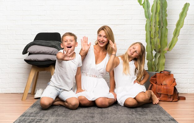 Madre con sus dos hijos en el interior saludando