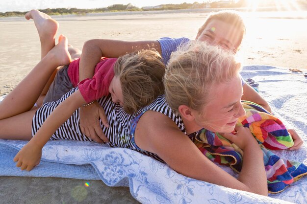 Madre y sus hijos en la playa al atardecer Georgia
