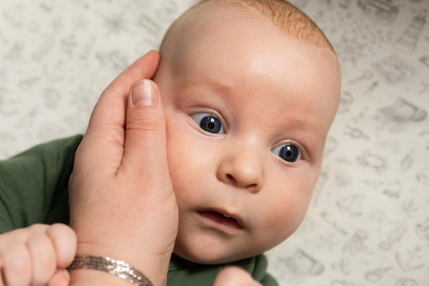 la madre toca suavemente la cara del bebé