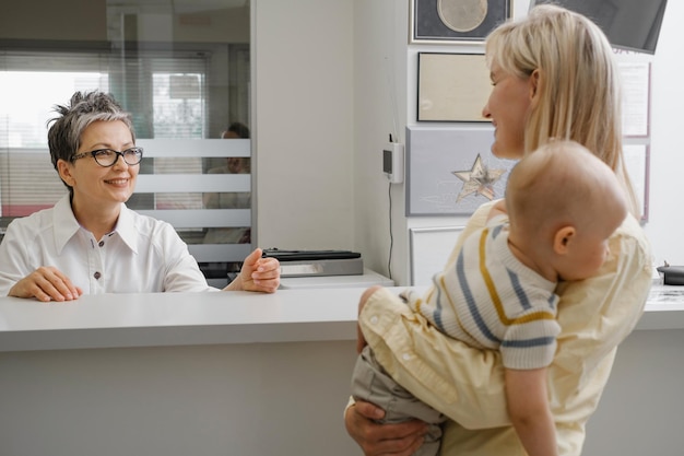 La madre toma el historial médico antes de la cita con el médico en el hospital en la clínica