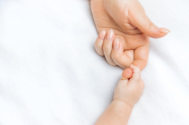 Foto la madre toma la mano del bebé.