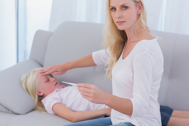 Madre tomando la temperatura de su hija