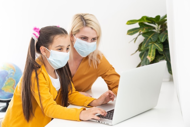 Madre trabajando desde casa con niños. Escuela en cuarentena y cerrada durante el brote de coronavirus. Educación en casa y trabajo independiente. niña jugando. trabajo a distancia.