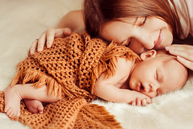 Madre tumbada encima de un bebé