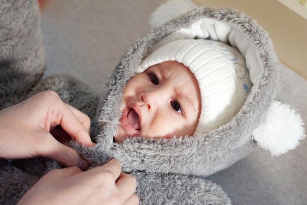 Una madre vistiendo a su pequeño bebé en casa paternidad infantil y crecimiento concepto familiar personas reales