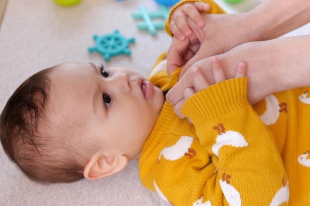 Una madre vistiendo a su pequeño bebé niño en casa infancia paternidad y crecimiento concepto de familia personas reales